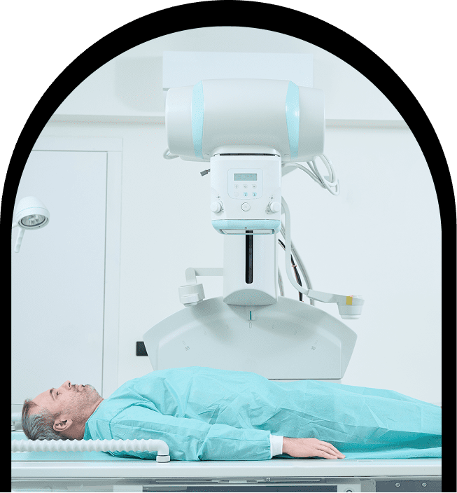 Patient lying under large imaging scanner